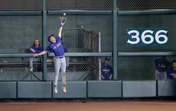 Texas Rangers center fielder Evan Carter (32) makes a catch at the wall during the eighth inning of game one of the ALCS against the Houston Astros in the 2023 MLB playoffs at Minute Maid Park.